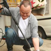 Mr. Yoshinaga sprays a toy clean with a pressure washer. | EDAN CORKILL PHOTO