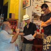 Seeking answers: Kang family friend Ray  Wozniak hands out flyers in Kabuki-cho while visiting  Tokyo in 2011 to find information about the death of Scott Kang. | SIMON SCOTT