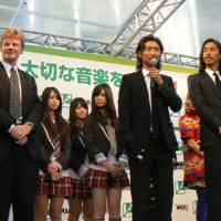 Bringing out the big guns: Exile\'s Makidai speaks to a crowd on Dec. 6 in Shinjuku alongside band member Akira (right) and John Kennedy (left) of the International Federation of the Phonographic Industry. | KAZUAKI NAGATA PHOTO