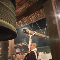 In with the new: A Buddhist priest rings the bell at Sensoji in Tokyo last year. | JUDIT KAWAGUCHI PHOTO