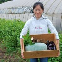 Irregularity issues: Vegetable Equality\'s CEO, Mitsuko Mori, holds a box of \"irregular\" organic vegetables. | MELINDA JOE PHOTO