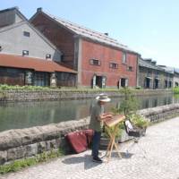 Water music: A busker performs by the Otaru Canal, built in 1923. | DANIEL ROBSON PHOTOS
