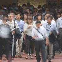 Not much jingling: Morning commuters exit Tokyo Station last week. The average Japanese husband\'s monthly allowance slumped to the lowest level since 1982. | BLOOMBERG