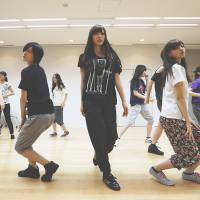 Seeking a toehold: Members of Sony Corp.\'s girl group Nogizaka 46, (from front left) Sayuri Matsumura, Rina Ikoma, Mai Shiraishi and Nanase Nishino, practice dance moves for a new song with colleagues at Sony Music Entertainment (Japan) Inc. headquarters in Tokyo on June 28. | BLOOMBERG
