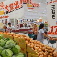 The price is right: Shoppers check out vegetables offered at discount prices at an Ito-Yokado supermarket in Katsushika Ward, Tokyo, on Wednesday. | KYODO