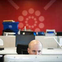 Opening up: A contractor for the General Services Administration uses the agency’s flexible workspace in Washington on June 18. The office was revamped to create an open workspace in which desks are shared and “teleworking” is encouraged. Does U.S. agency's new office represent the workplace of the future?