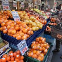 Shipped direct: A shopper looks at fruit outside a Tokyo supermarket. Consumers in other parts of Asia may be able to order fruit like this online if the Trans-Pacific Partnership stimulates global trade. | BLOOMBERG