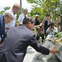 Atonement: Former Nagasaki Mayor Hitoshi Motojima (left) places flowers Sunday at a new monument in the city of Nagasaki commemorating Chinese who died from the atomic bombing in August 1945. | KYODO