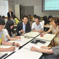Corporate input: Tatsuo Hirase (third from left) of Mitsui &amp; Co. holds a group discussion at Aichi Prefectural University, where he delivered a lecture in June. | CHUNICHI SHIMBUN