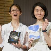 Laureates: Naoki prize winner Shino Sakuragi (left) and Akutagawa award winner Kaori Fujino hold their award-winning books Wednesday at a press conference in Tokyo. | KYODO