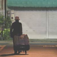 Stealing away: An elderly man pulls a cart as he walks through an alley at night in Tokyo on July 8. | BLOOMBERG