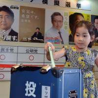 The youth vote: A girl casts a vote in front of posters for major political parties at the Kidzania career theme park in Tokyo on Friday. Children took part in a mock vote to learn about the political process ahead of Sunday’s Upper House election. Major parties concerned about voter turnout