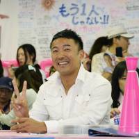V for victory: Actor Taro Yamamoto celebrates Sunday evening at his campaign office in Tokyo after his victory in the Upper House election was assured. | KYODO
