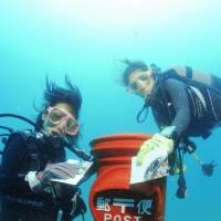 Fan mail from some flounder?: Divers mail water-resistant postcards in a postbox 10 meters down off the town of Susami, Wakayama Prefecture, in June 2012. | CLUB NOAH SUSAMI/KYODO