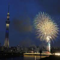 Brief bang: Fireworks light up the sky Saturday along the Sumida River in Tokyo before it was canceled by a thunderstorm. | KYODO