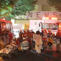 Bad reaction: Women who started feeling sick during an outdoor concert by the pop group NEWS are taken to the hospital in Tokyo\'s Aoyama district late Saturday night after the show was halted by rain. | KYODO