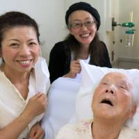 Age 96: Hisako Miyake, center, with her family members, from left to right, Kazuko Miyake, daughter-in-law of Hisako Miyake and aunt of this article\'s reporter Kanoko Matsuyama, Ritsuko Matsuyama, daughter-in-law of Hisako Miyake and mother of Kanoko, and Kanoko Matsuyama, grandchild of Hisako Miyake, in a hospital in Nara on June 16. | THE MATSUYAMA FAMILY/BLOOMBERG