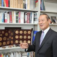 Newly minted: Ichiro Fujisaki, new president of the America-Japan Society, Inc. and former ambassador to the U.S., speaks to The Japan Times in front of his collection of commemorative coins of U.S. presidents on July 11. | YOSHIAKI MIURA