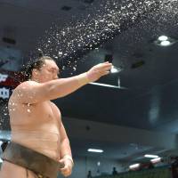 Already done: Hakuho throws salt prior to his match against Kotooshu at the Nagoya Grand Sumo tournament on Friday. Hakuho clinched the title with two days to spare.   | KYODO