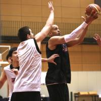 All for country: J.R. Sakuragi (right) takes a layup as Sean Hinkley goes for a block during Japan\'s national team training camp at the National Training Center on Sunday. | KAZ NAGATSUKA