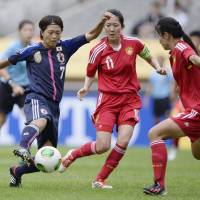 Foot skills: Japan\'s Kozue Ando (left) dribbles the ball against China in the Women\'s Asian Cup opener in Seoul on Saturday. Ando scored a goal in Japan\'s 2-0 triumph. | KYODO