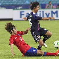 In the heat of the moment: Japan\'s Mana Iwabuchi (right) is tackled by South Korea\'s Lim Seon-joo during their Women\'s East Asian Cup match in Seoul on Saturday. South Korea defeated Japan 2-1. | AP