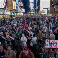Peaceful protest: Throngs of demonstrators gather during a march in New York\'s Times Square early Sunday for a protest against the acquittal of George Zimmerman in the 2012 killing of 17-year-old Trayvon Martin in Florida. | AP