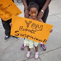 Youth message: Jediah Jones, 3, holds a sign Sunday in Atlanta as her mother, Keiota Jones, stands behind her during a protest the day after George Zimmerman was found not guilty in the 2012 shooting death of teenager Trayvon Martin. | AP