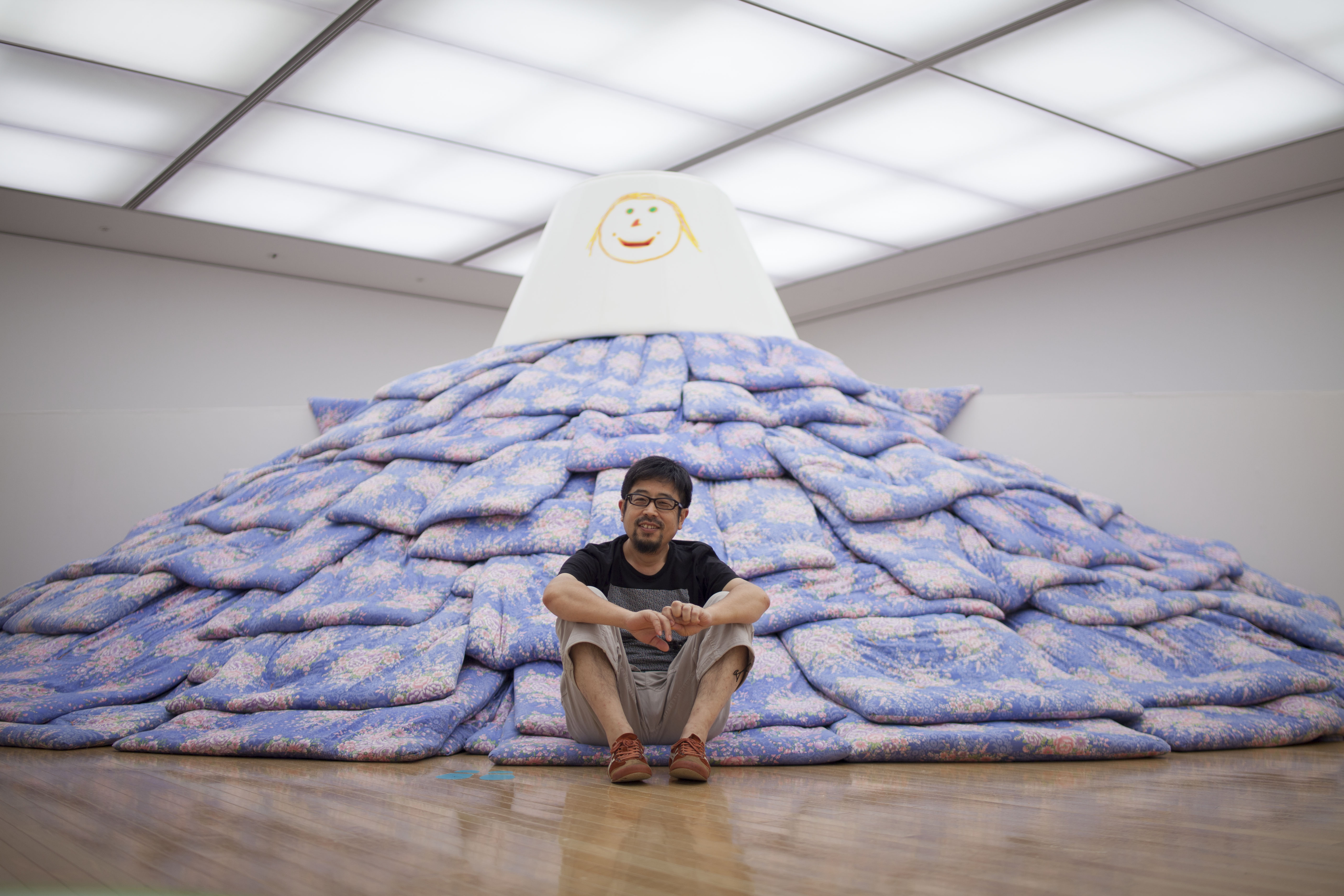 Work and play: Tsuyoshi Ozawa with a mountain of futons, which he created for kids in Fukushima. | KENJI AOKI