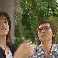 Emiko Okada (right) and her daughter, Yukie Tominaga, ring a Peace Bell in Hiroshima Peace Memorial Park in summer 2006. | COURTESY OF SMARTGIRL PRODUCTIONS LLC