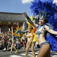 Carnival queens: Costumed revelers parade through the streets of Tokyo during a previous Asakusa Samba Carnival. | KYODO