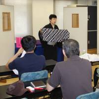Rakugo storyteller Katsura Udanji explains how to use a washcloth as a stage prop at a hall in Ueno in Tokyo the same day. | MASAAKI KAMEDA
