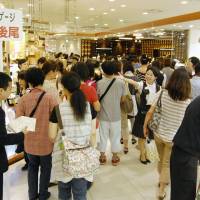 Hustle and bustle: Shoppers crowd the food floor at Kintetsu Department Store\'s flagship outlet in the Abeno Harukas building in Osaka on Monday. | KYODO