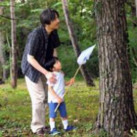 Summer fun: Prince Hisahito catches insects with Prince Akishino at the Imperial Villa in Tochigi Prefecture on Aug. 18. | KYODO PHOTO