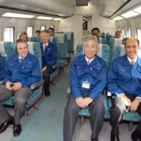 On track: U.S. Ambassador John Roos (right), sitting next to JR Tokai Chairman Yoshiyuki Kasai, rides a maglev train on the railway operator\'s test track in Yamanashi Prefecture on Friday. | KYODO PHOTO