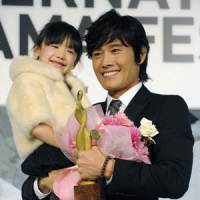Megastar: South Korean actor Lee Byung Hun holds Japanese child actress Mana Ashida after receiving the Best Actor in Asia award Monday in Tokyo. | KYODO PHOTO