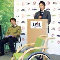 Wood to go: Baseball commentator Norihiro Akahoshi, who was once on the verge of requiring a wheelchair due to an injury, shows off Japan Airlines Corp.\'s bamboo wheelchair at Tokyo\'s Haneda airport. | KYODO PHOTO