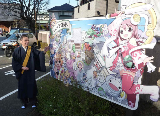 Animating Buddhism: Ryohoji's chief priest, Shoko Nakazato, poses beside the temple's 'anime' sign board in Tokyo's suburb of Hachioji on Dec. 11. | KYODO PHOTOS