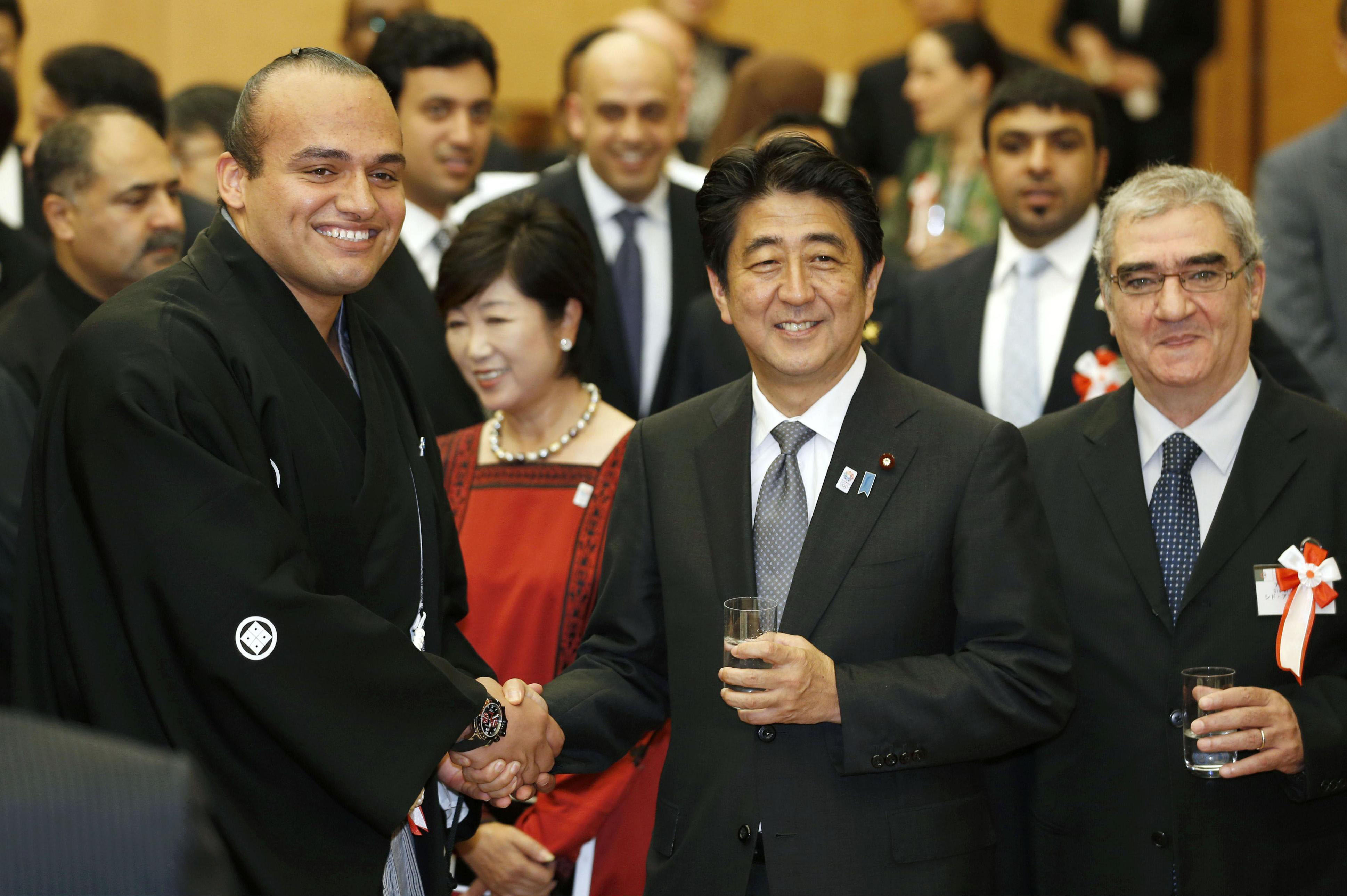 Fast friends: Prime Minister Shinzo Abe poses with sumo wrestler Osunaarashi, the first sekitori from Africa, during an 'iftar' dinner party at the prime minister's office Wednesday. | KYODO
