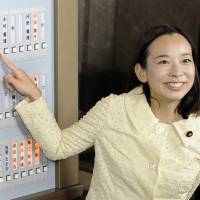 Japanese Communist Party lawmaker Yoshiko Kira presses a button to show her attendance at the Diet. | KYODO