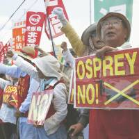 Speaking up: Residents stage a rally Saturday morning at one of the gates for the Futenma airbase in Okinawa Prefecture to protest the arrival of more Osprey aircraft. | KYODO