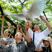 High hopes: Symbolizing their wish for world peace, people release doves Thursday at Yasukuni Shrine in Tokyo. | SATOKO KAWASAKI