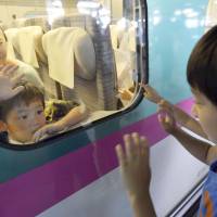 Such sweet sorrow: Two cousins who spent the Bon holidays together part at JR Sendai Station on Saturday as the rush of travelers returning home peaked. | KYODO