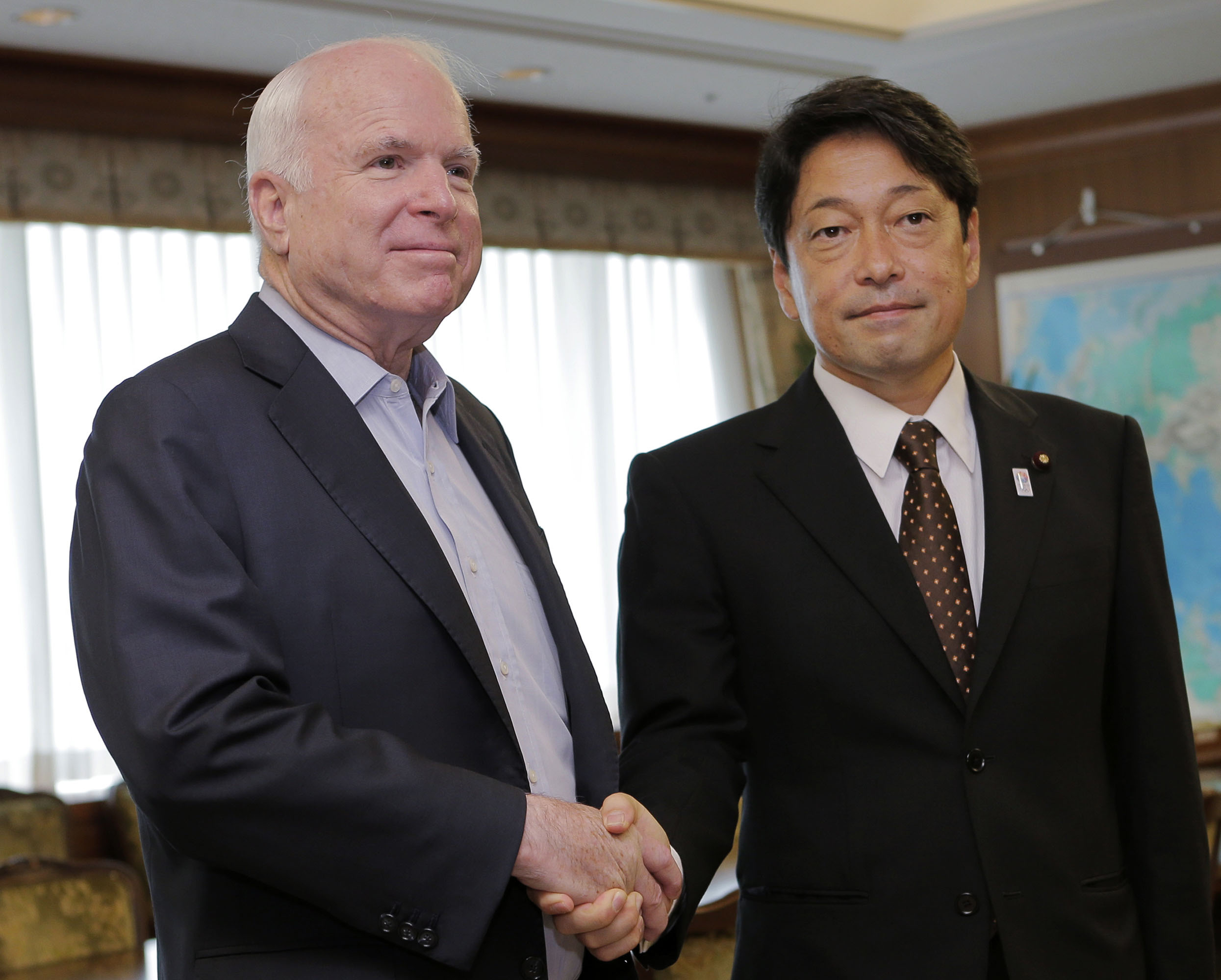 Hand in glove: Visiting U.S. Sen. John McCain (left) and Defense Minister Itsunori Onodera pose for a photograph prior to their meeting at the Defense Ministry on Wednesday. | AP