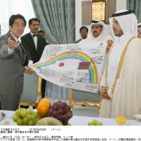 Messenger: Prime Minister Shinzo Abe on Wednesday in Doha presents his Qatari counterpart, Sheikh Abdullah Bin Nasser Bin Khalifa Al Thani, with a banner bearing messages from residents of tsunami-hit Onagawa, Miyagi Prefecture, that thank the people of Qatar for their support in the aftermath of the March 2011 disaster. | KYODO