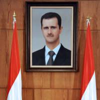 Official response: Syrian Foreign Minister Walid al-Moallem speaks under a portrait of President Bashar Assad during a conference in Damascus on Tuesday.  | AFP-JIJI