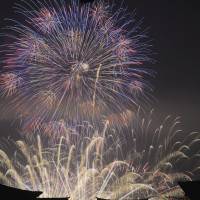 Fireworks light up the sky above Itsukushima Shrine, a UNESCO World Heritage Site.   | KYODO
