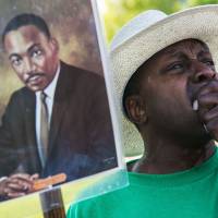 Slow march to parity: A man weeps during the commemoration of the 50th anniversary of the March on Washington at the National Civil Rights Museum in Memphis, Tennessee, on Wednesday. Black-white economic gap in U.S. is still as wide as ever