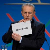 International Olympic Committee President Jacques Rogge shows a card displaying Tokyo, the city  chosen to host the 2020 Summer Olympics, in Buenos Aires, Saturday. | AP