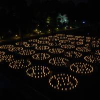 Lighting up the night: Candles wrapped in paper bear messages from residents of Tohoku that express sentiments about the 2011 Great East Japan Earthquake. The event is organized by Tama University\'s Maruyama Seminar. | REBECCA MILNER